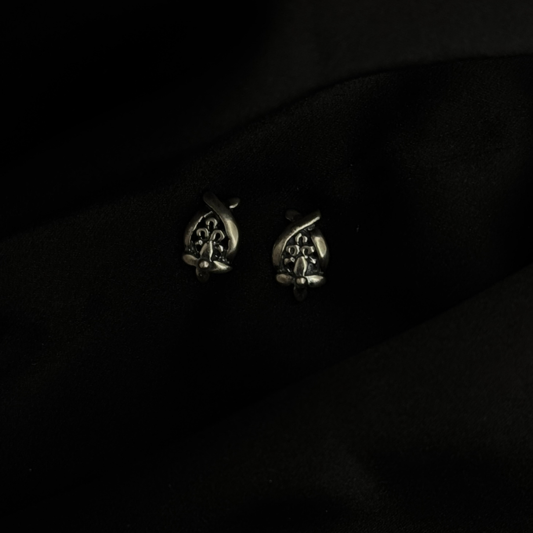Pair of silver earrings on a black background