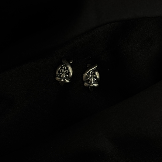 Pair of silver earrings on a black background