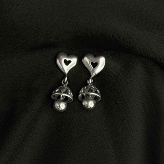Silver heart-shaped earrings on a black background