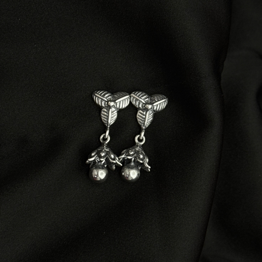 Silver brooch with leaf design on a black fabric background