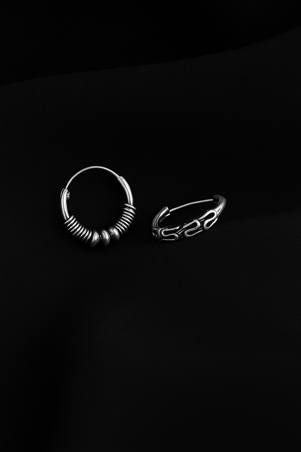 Two silver rings on a black background