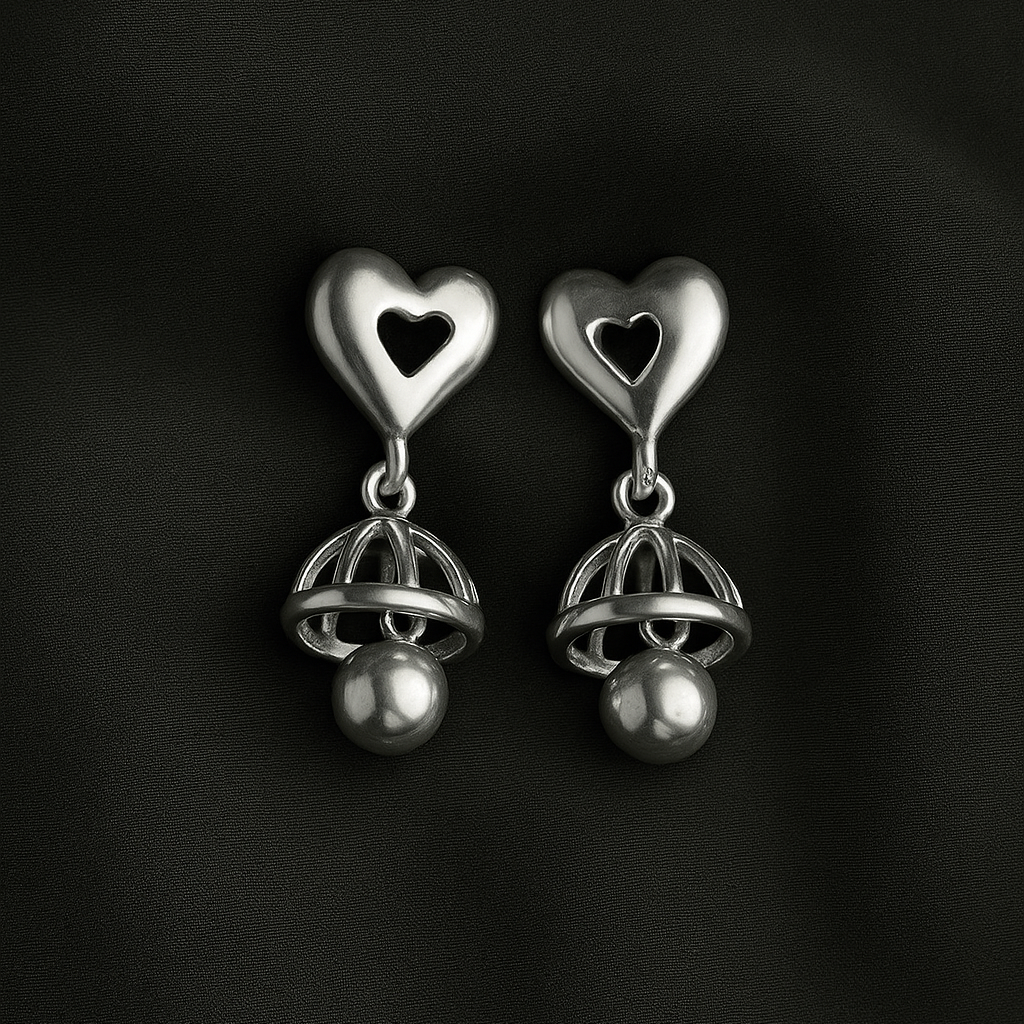 Pair of silver heart-shaped earrings on a black background