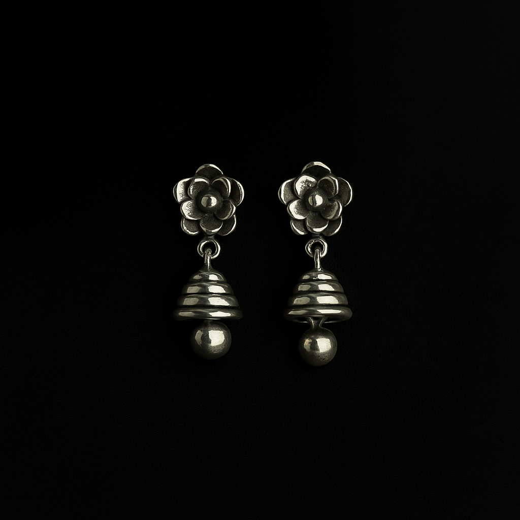 Pair of silver flower-shaped earrings on a black background
