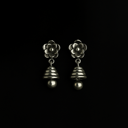 Pair of silver flower-shaped earrings on a black background