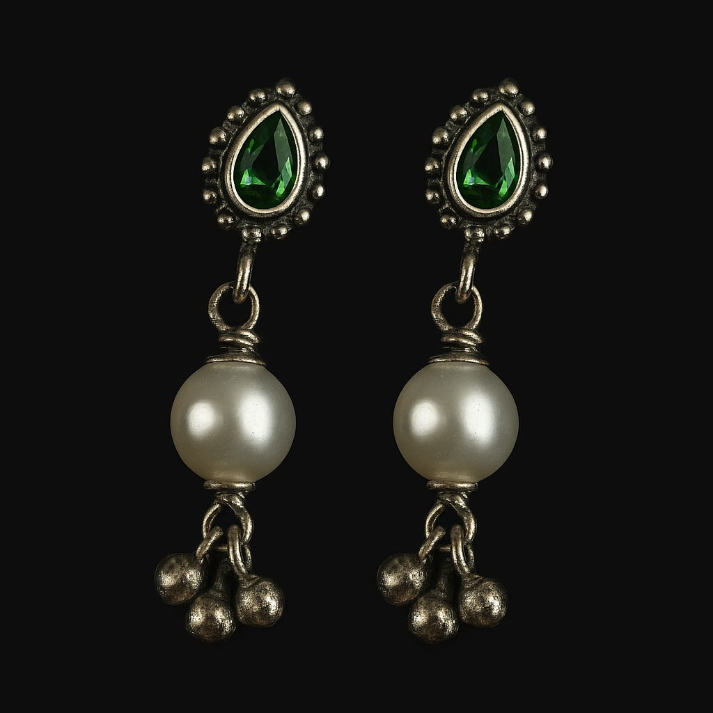 Pair of earrings with pearls and green gemstones on a black background