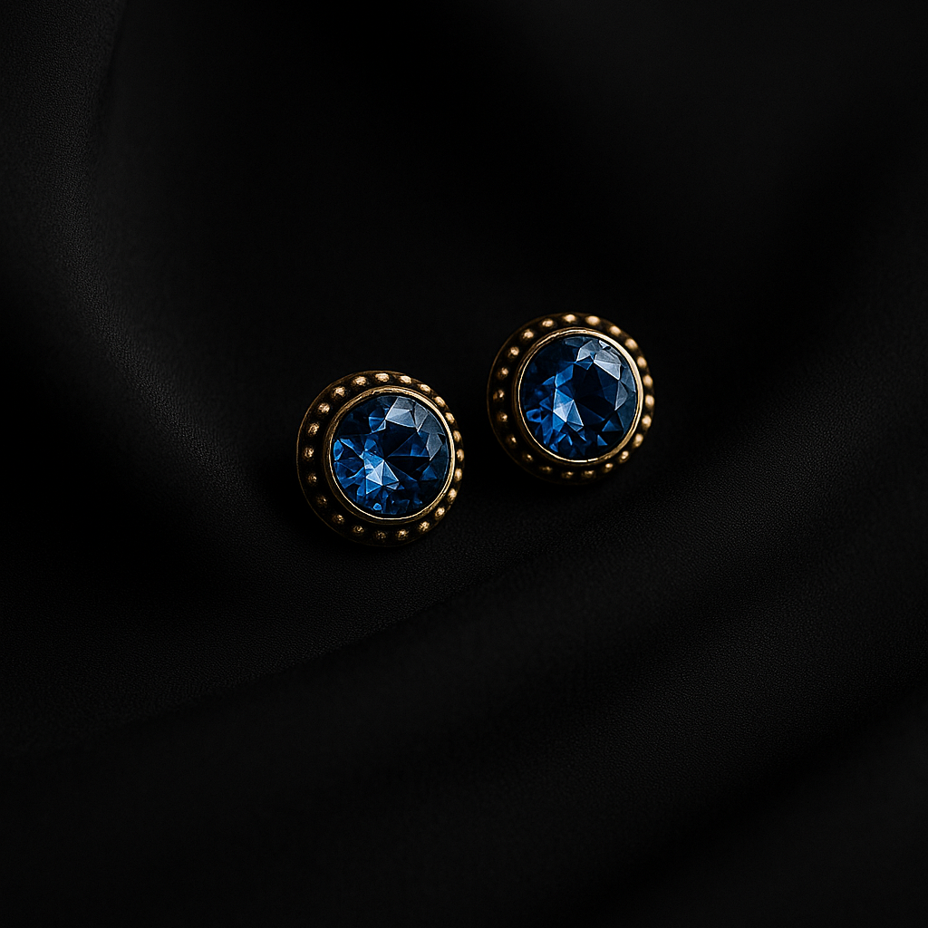 Pair of round earrings with blue gemstones on a black background