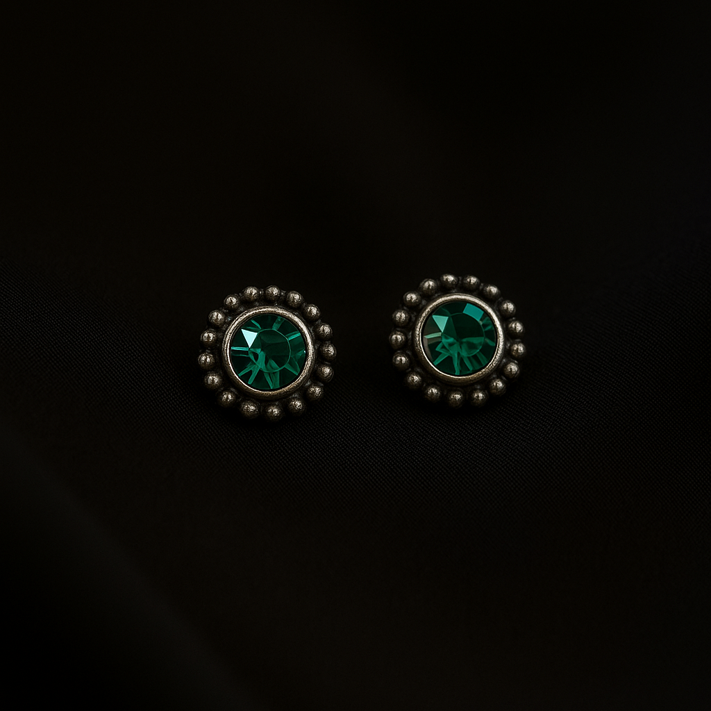 Pair of earrings with green gemstones on a black background