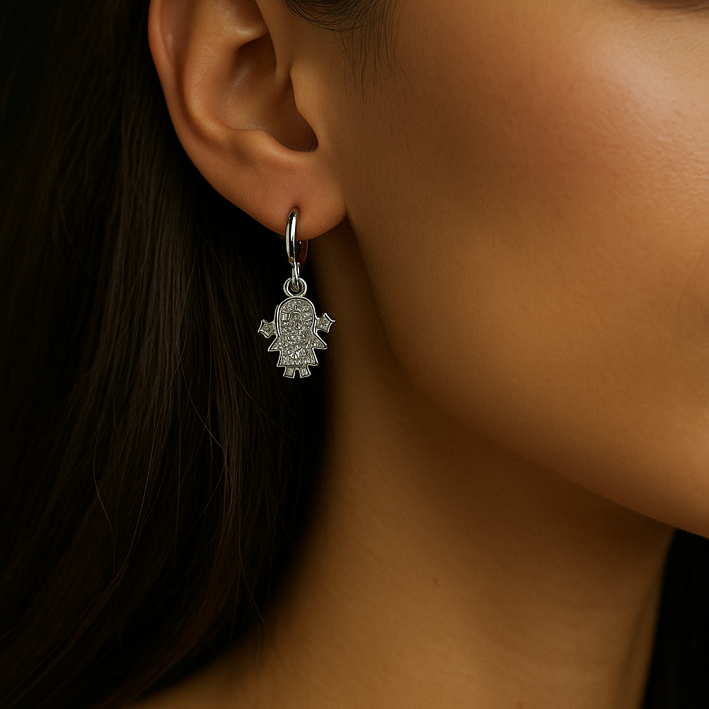 Close-up of a woman wearing a silver hamsa hand earring.