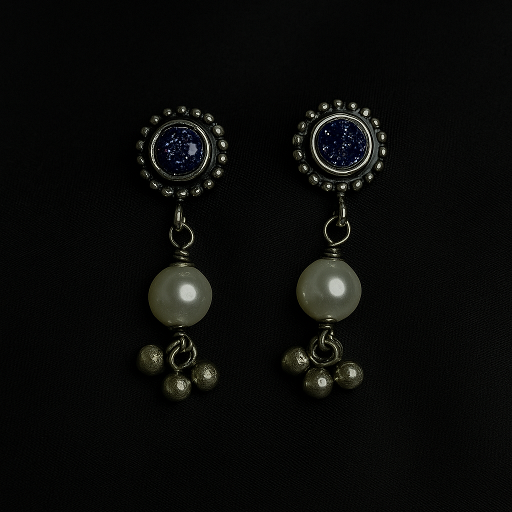 Pair of earrings with pearls and gemstones on a black background