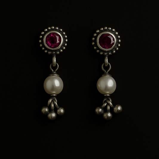 Pair of earrings with gemstones and pearls on a black background