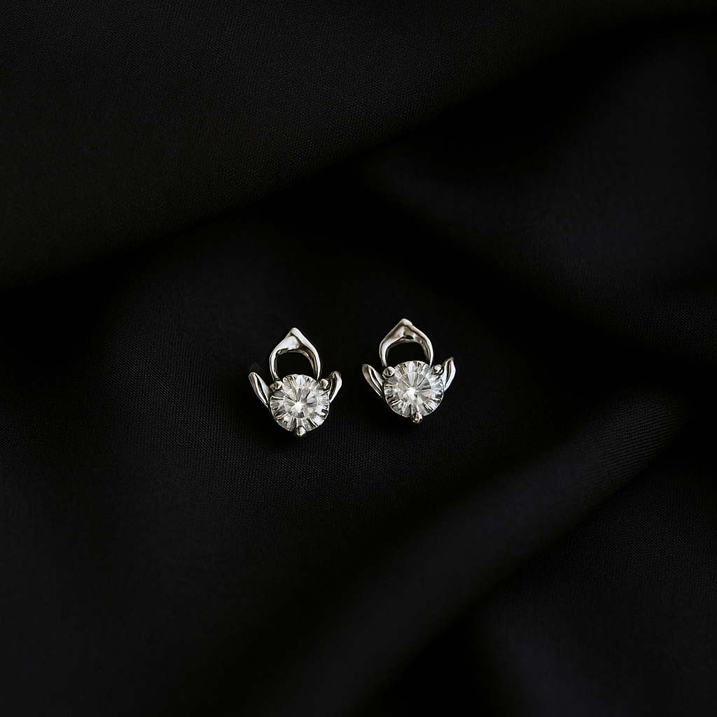 Pair of silver earrings on a black fabric background