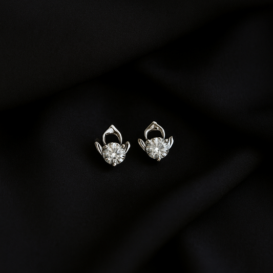 Pair of silver earrings on a black fabric background