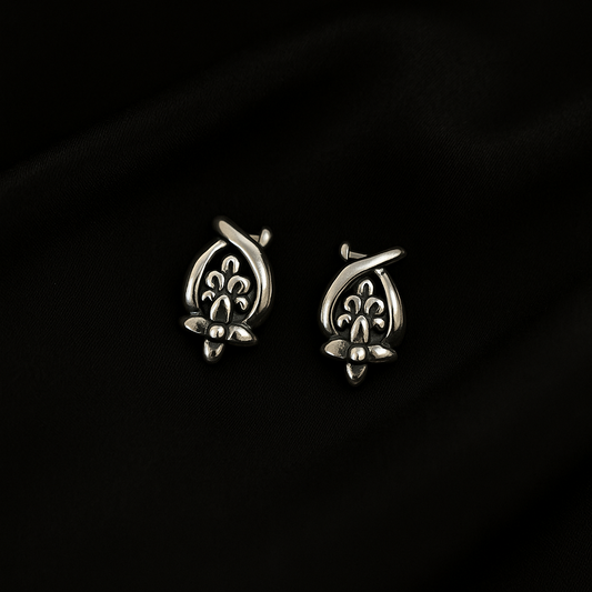 Pair of silver earrings on a dark background