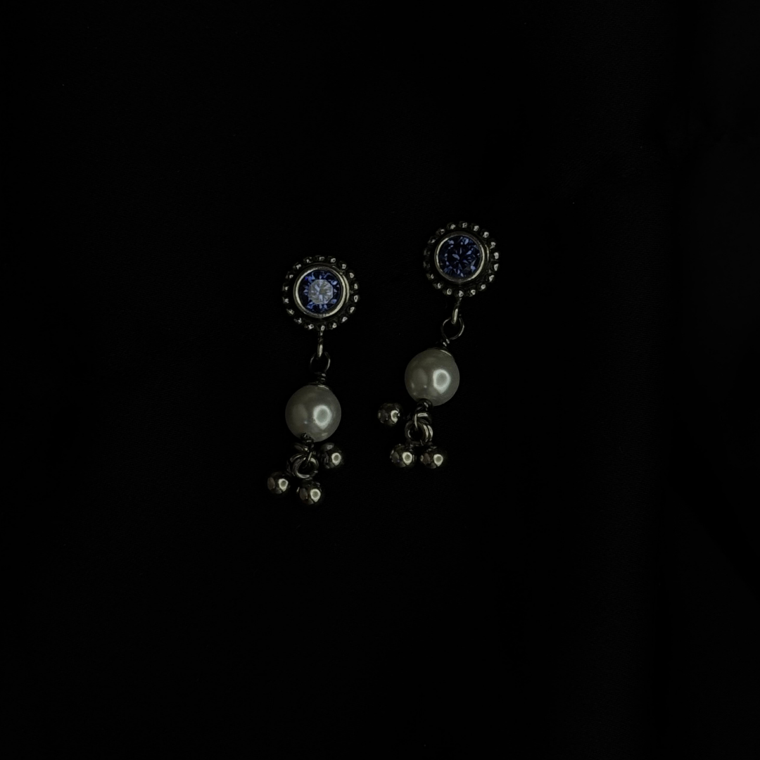 Pair of earrings with dark gemstones on a black background