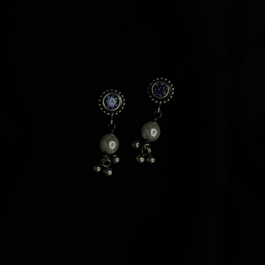 Pair of earrings with dark gemstones on a black background
